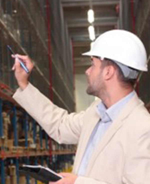 AMS employee taking inventory in warehouse, wearing a white hard hat