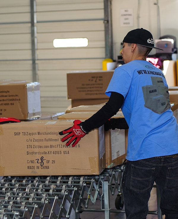 AMS warehouse working on packing line sending product box to shipping area.