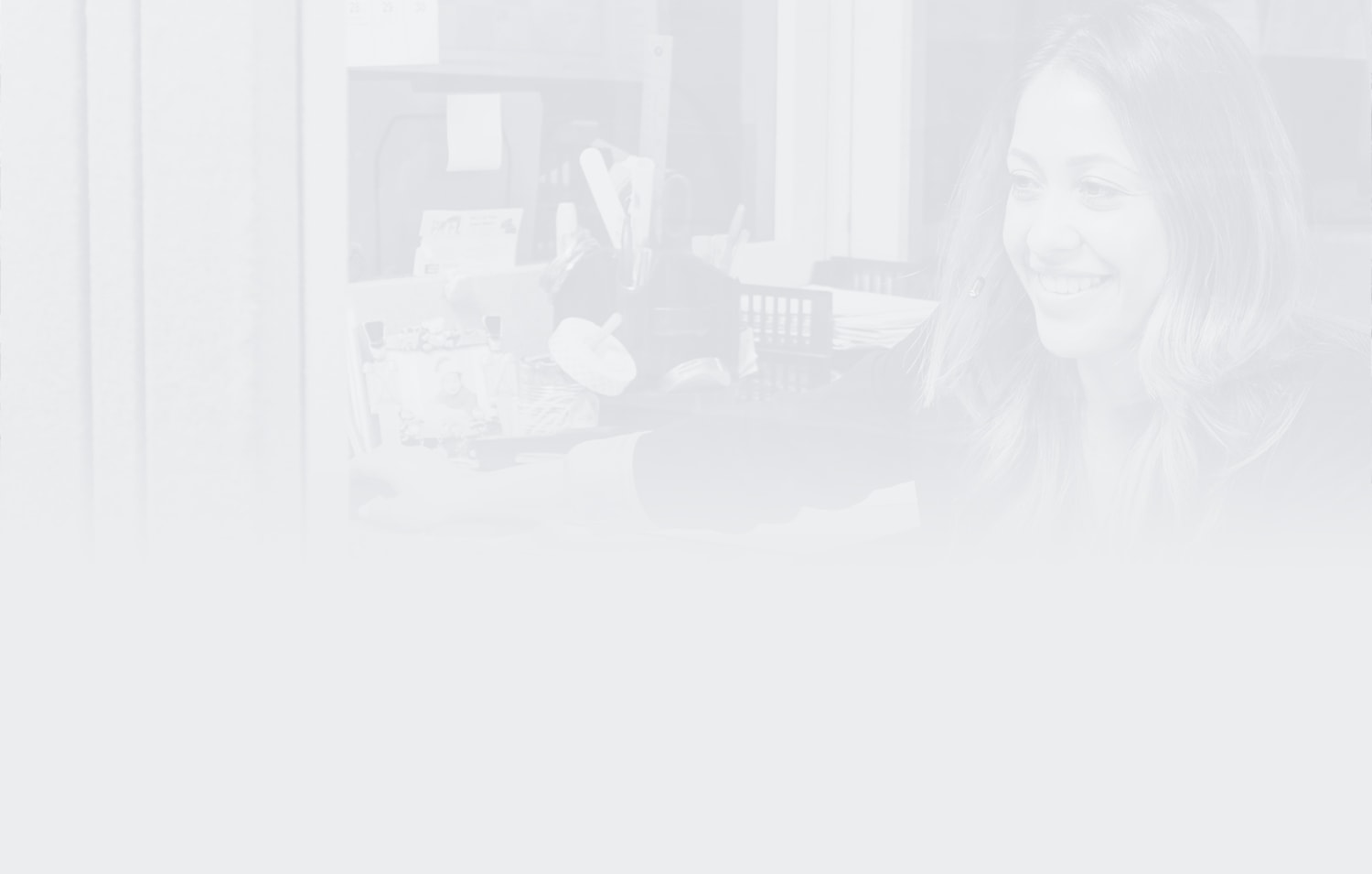 Transparent image of AMS employee working at a desk and smiling