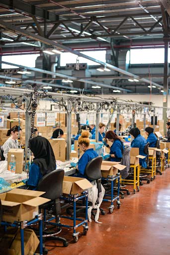 Workers sitting and fulfilling orders in an assembly line.