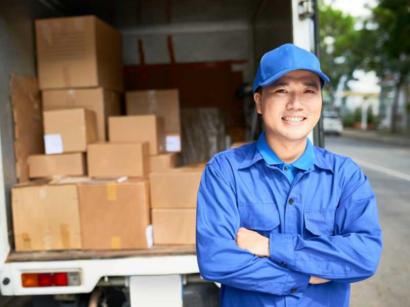 AMS worker standing in front of an open delivery truck.