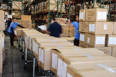 people organizing packages from conveyer - AMS Fulfillment