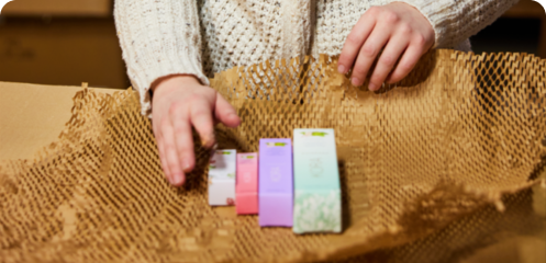 Person packaging various cosmetic products.