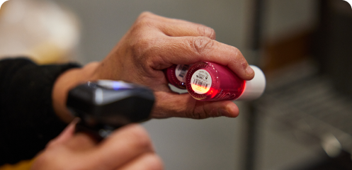 Person scanning the bottom of two nail polishes.