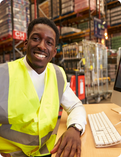 AMS employee wearing a safety vest and looking at the camera while smiling.