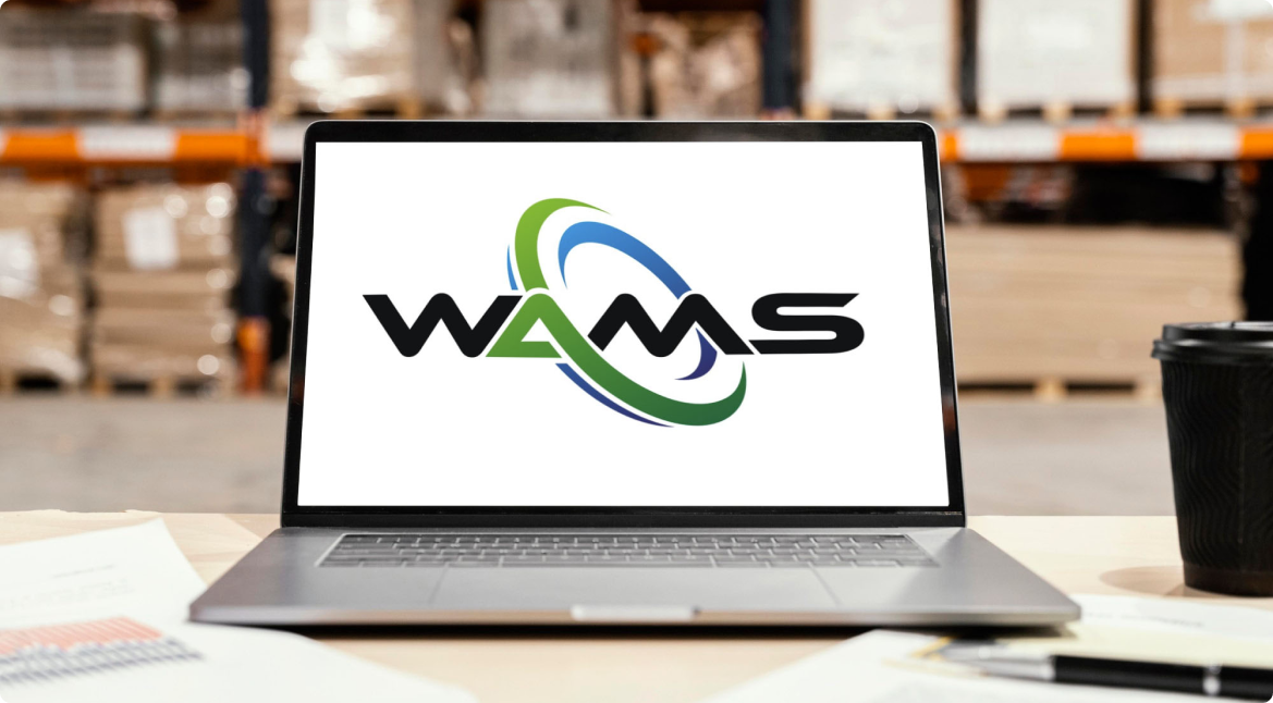 Laptop in a warehouse with WAMS logo displayed