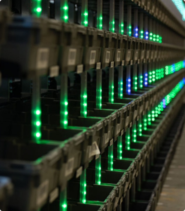 shelves with black containers and green lights.