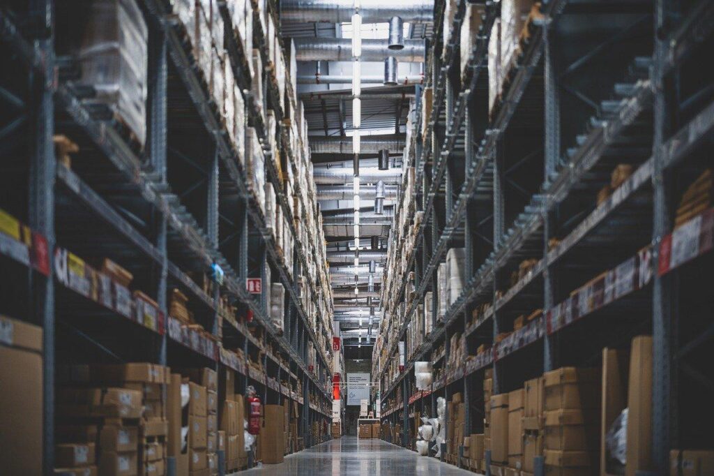 A warehouse aisle with shelves that are full of inventory.