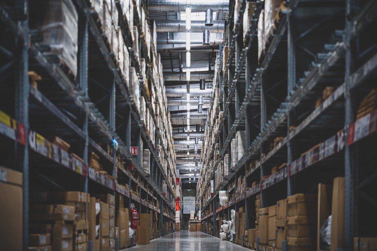 A warehouse aisle with shelves that are full of inventory.