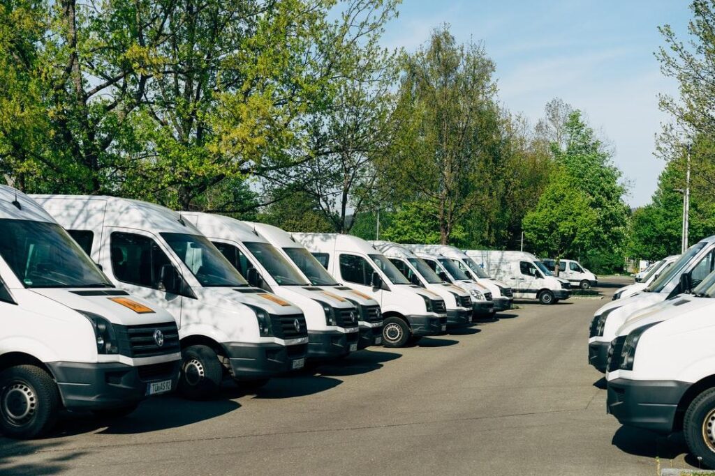 White cargo vans in a parking lot.